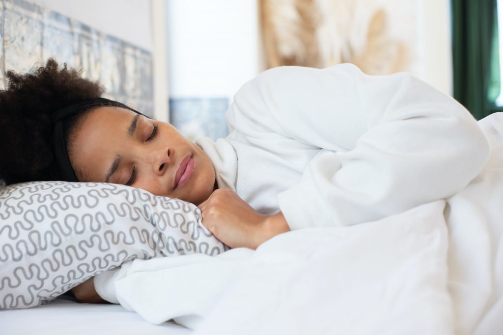 Persoon slaapt comfortabel op haar zij met een ondersteunend zijslaapkussen voor optimale nek- en rugsteuning